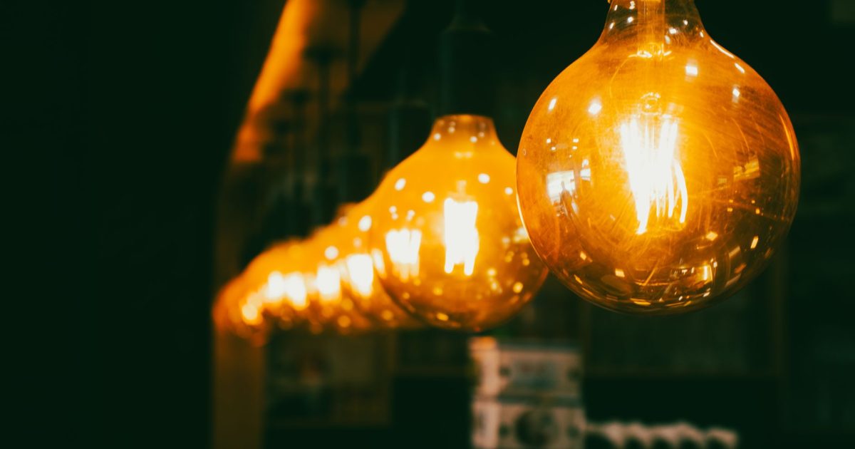 Close-up view of vintage light bulbs emitting a warm glow in a dim indoor setting.