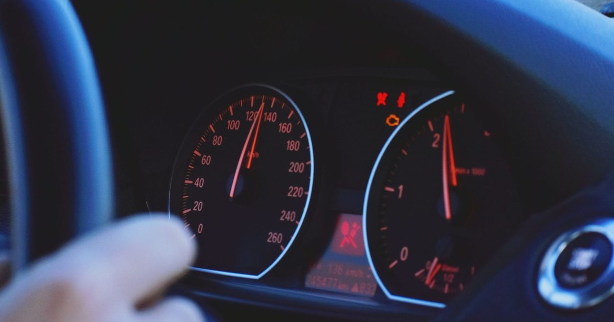 A detailed view of a car's speedometer and dashboard, emphasizing speed and technology.