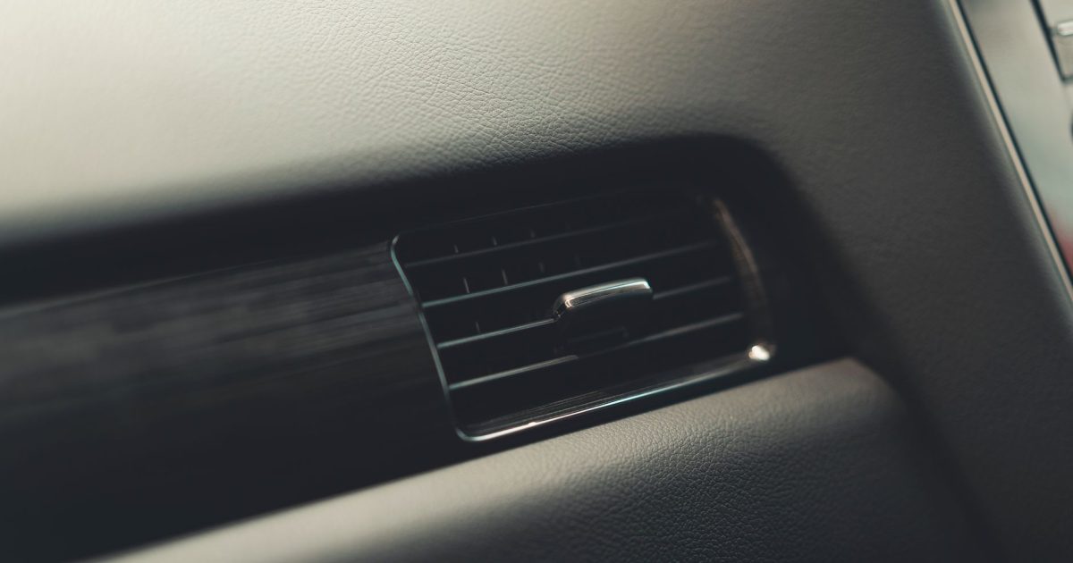 Detailed view of a car air vent system, showcasing interior design and texture.