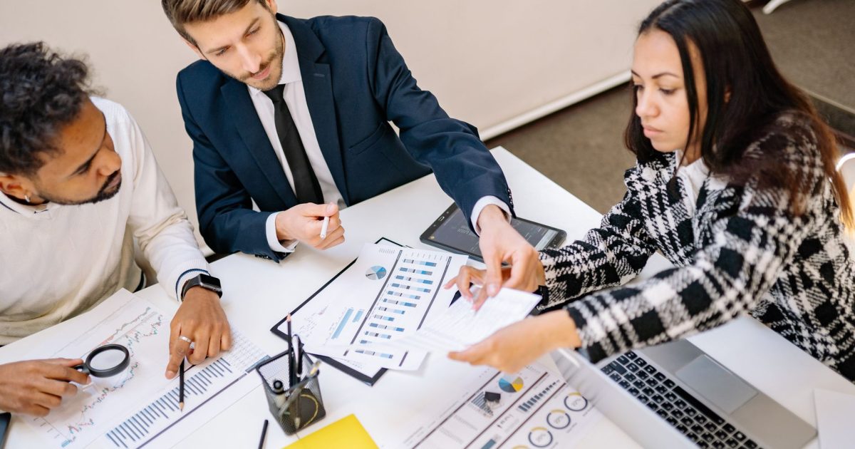 Business professionals engaging in a collaborative meeting with charts and documents.