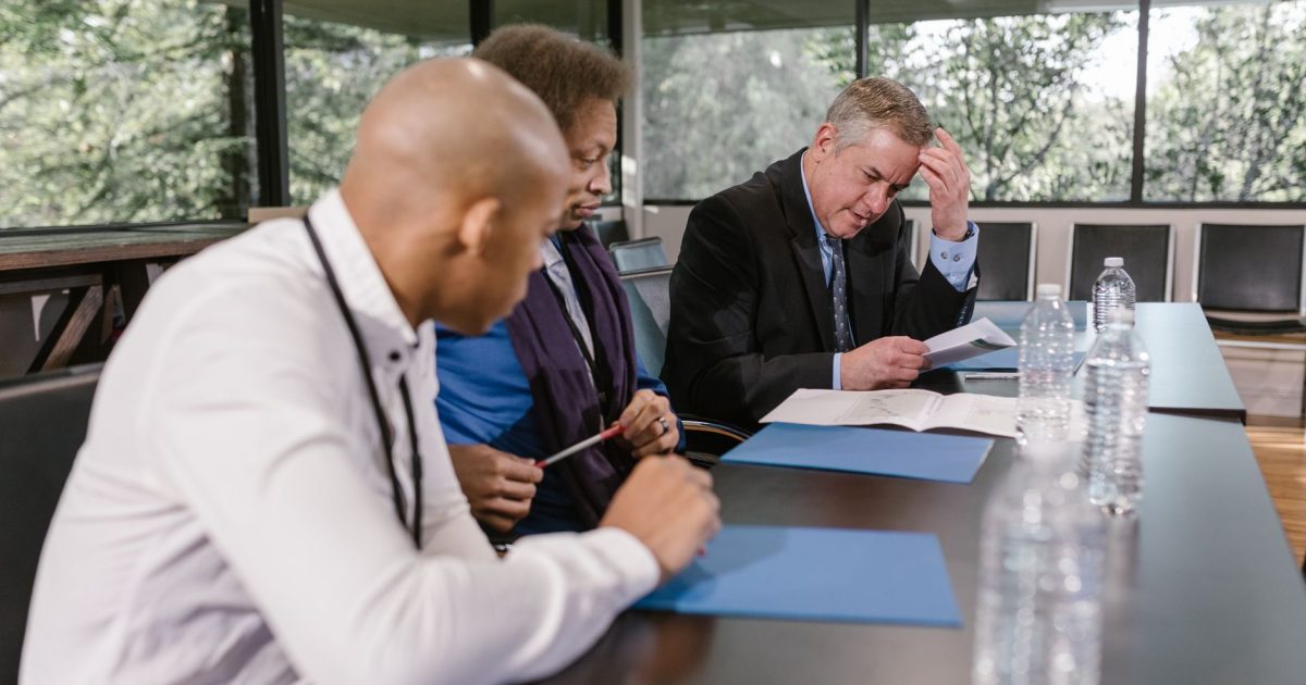 Group of diverse colleagues in a business meeting reviewing documents indoors.
