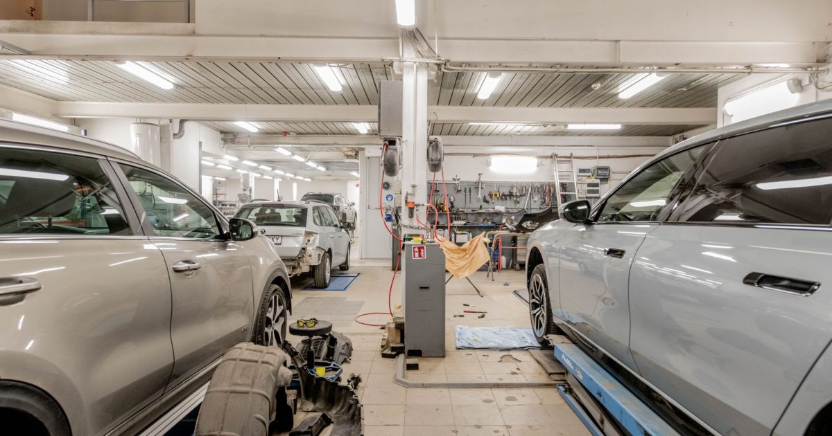 Interior of an automotive repair shop with cars undergoing maintenance and servicing.