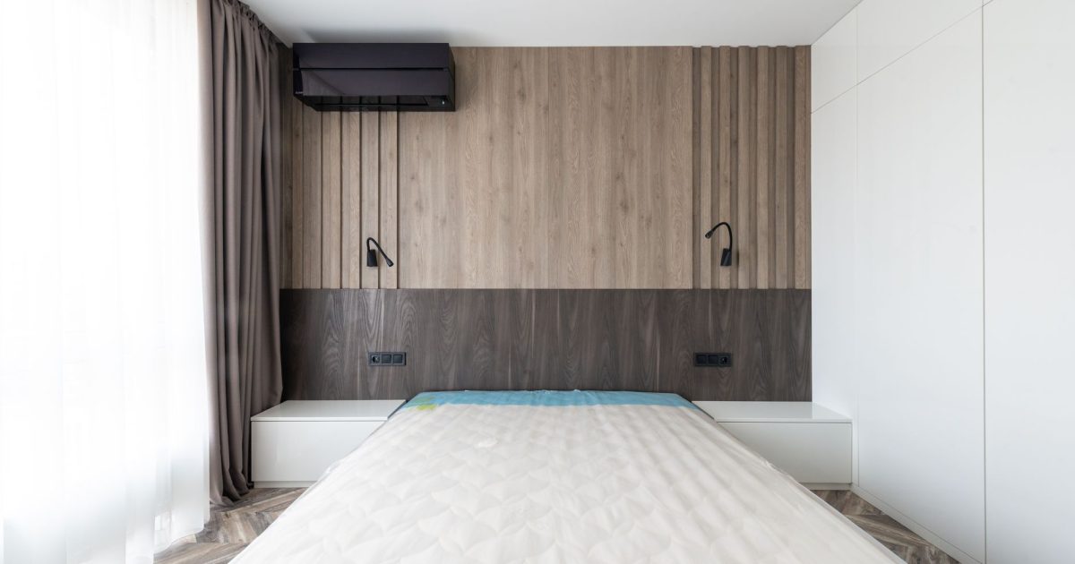 Sleek and modern bedroom featuring a minimalist design with wooden paneling and neutral tones.